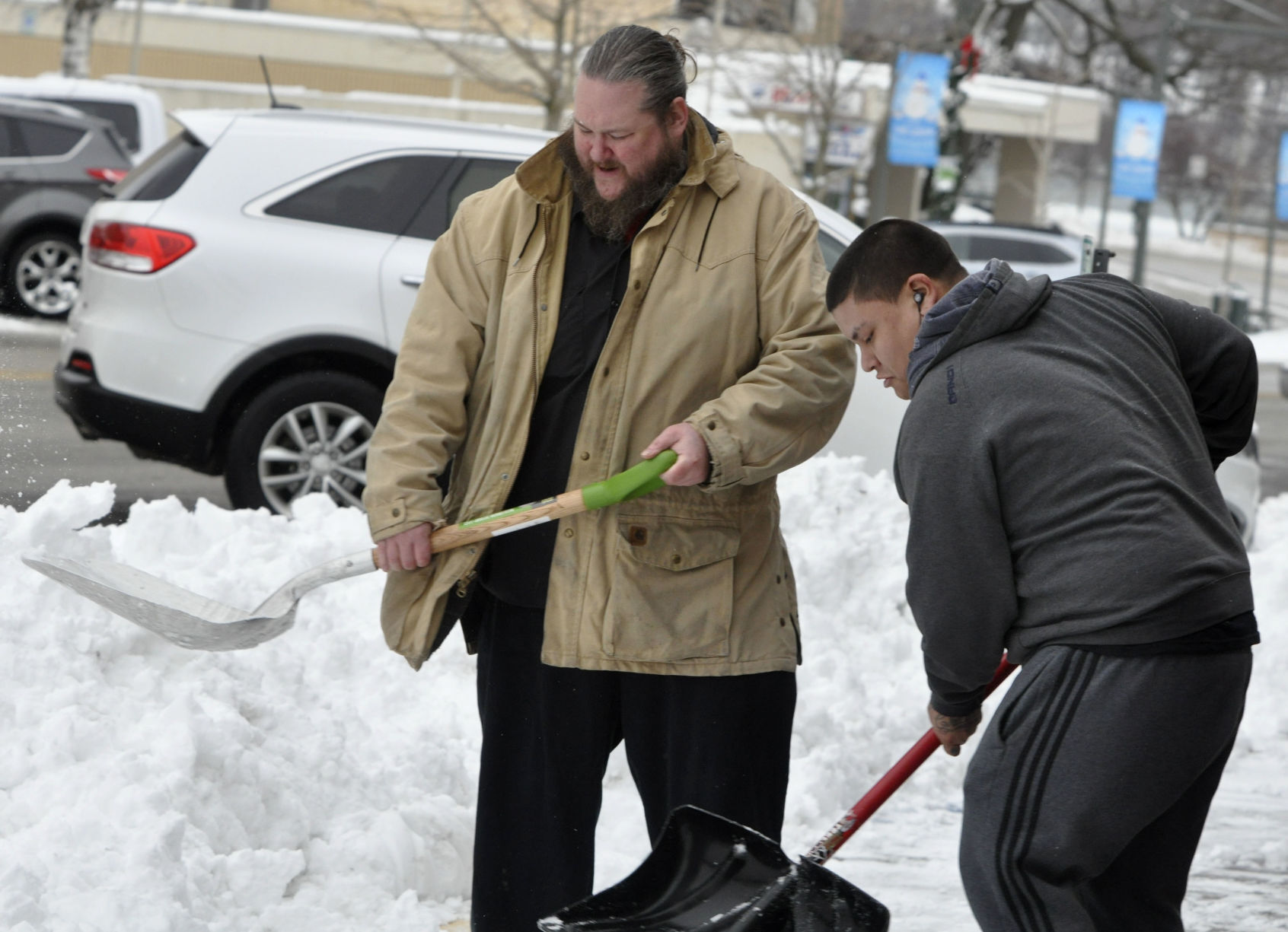 Kevin Kazimier, left, and Juan Grisales team up to shovel some snow in front of the Lake Aire Restaurant